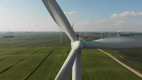 detail shot of a nose cone on a wind turbine in a green field in the usa