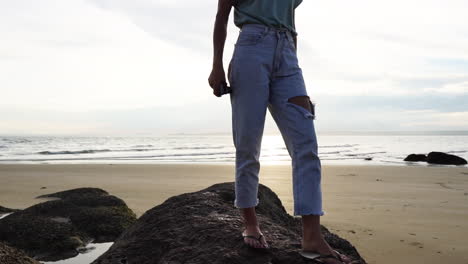 Beautiful-slim-redhead-walking-on-rocks-in-sandy-beach-in-Vietnam-coastline