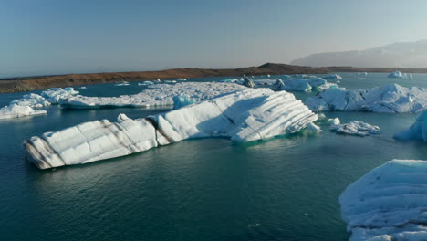 Vogelperspektive-Der-Eisigen,-Rissigen-Formation-Des-Gletschers-Im-Jokulsarlon-See-In-Island.-Vatnajökull-nationalpark-Lagune-über-Der-Breidamerkurjokull-gletscherzunge-Mit-Schwimmendem-Treibendem-Eisberg