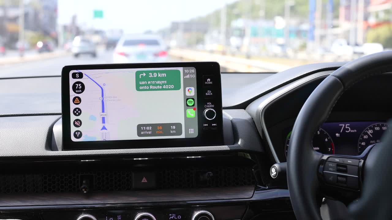 Interior car view with GPS navigation on display, driving through Phuket. Bright daylight, smooth road, and clear dashboard visuals