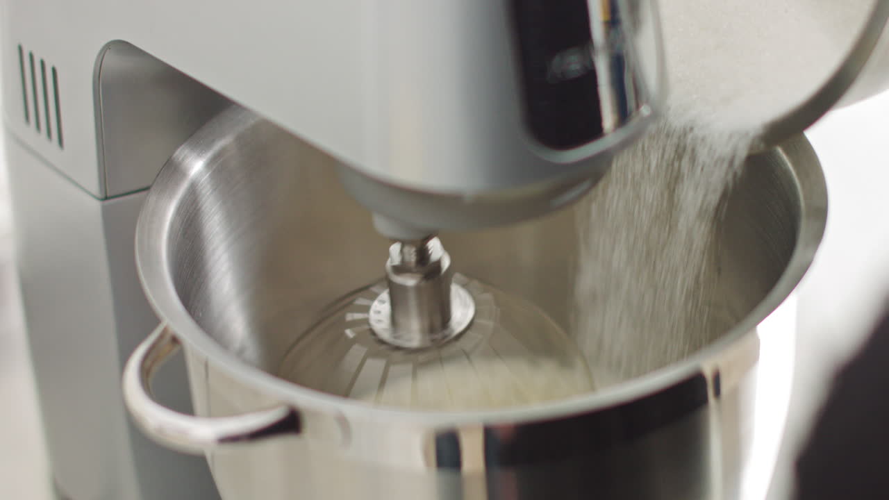Preparazione dell'impasto con una macchina impastatrice professionale che monta gli albumi con lo zucchero nel cibo