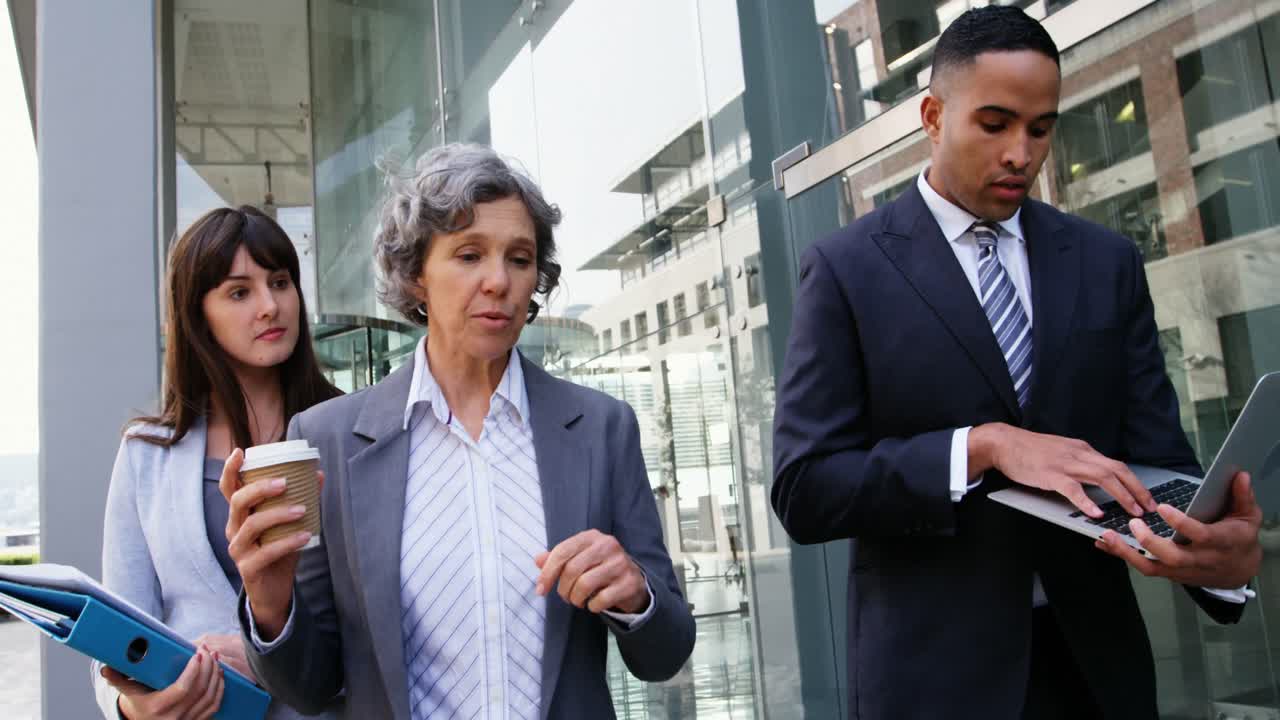 personas de negocios interactuando entre sí mientras caminan