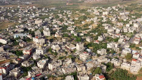 aerial view of a densely populated middle eastern town with residential buildings and a mosque