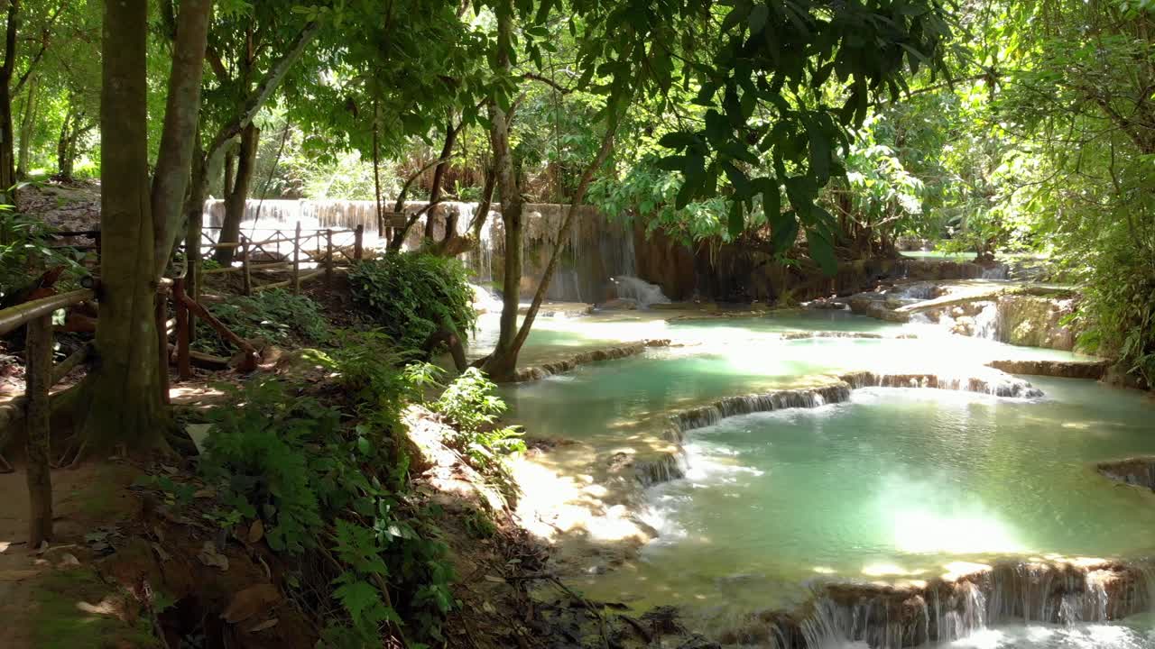 Panoramica 4K delle bellissime piscine a cascata turchesi presso le famose cascate di Kuang Si in Laos, Sud-est asiatico