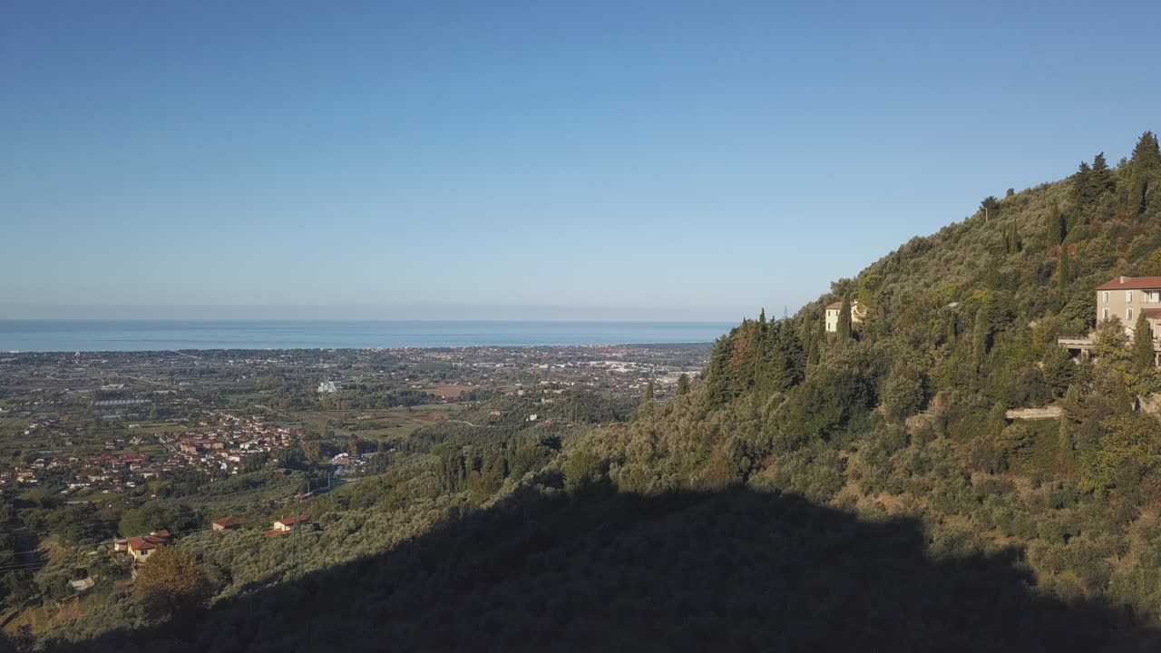 리도 디 카마이오레(lido di camaiore) 마을을 드러내는 아름다운 토스카나 언덕 위로 떠오르는 드론 공중 촬영