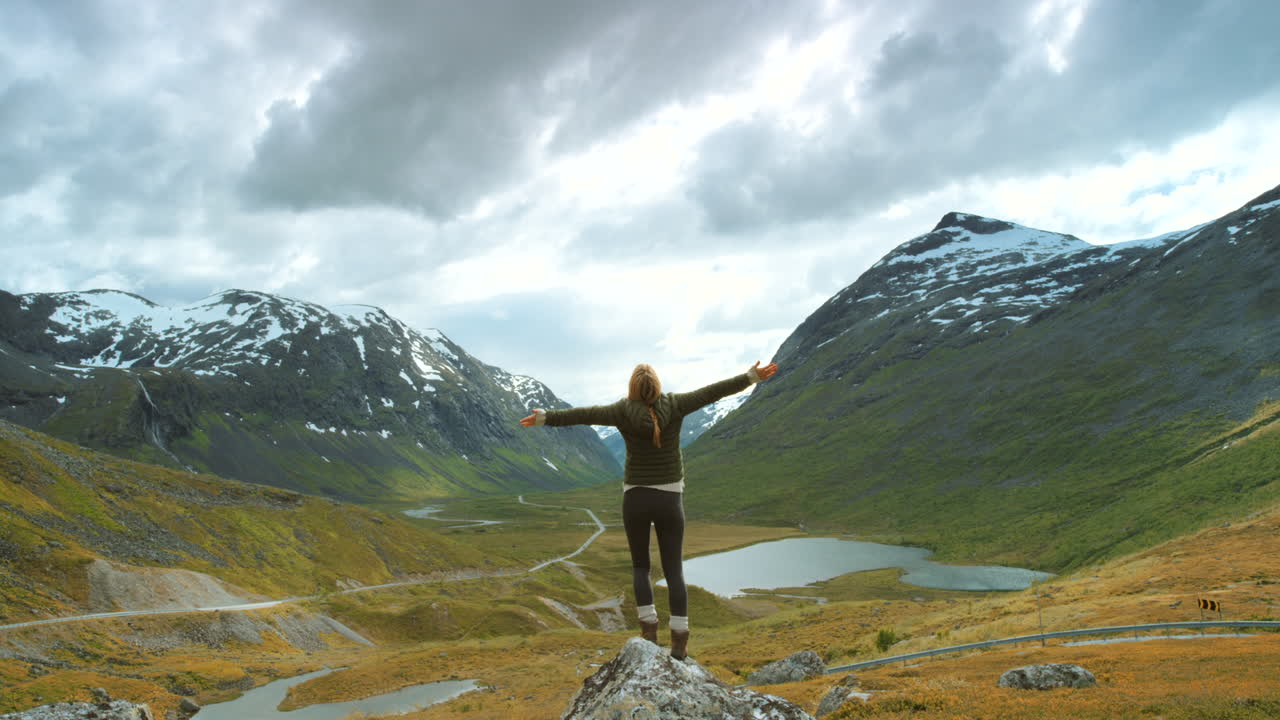 mujer disfrutando de la vista desde la cima de una montaña
