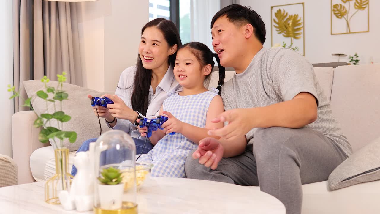 明るくモダンなリビングで、笑顔で笑いながらビデオゲームをする親と娘。