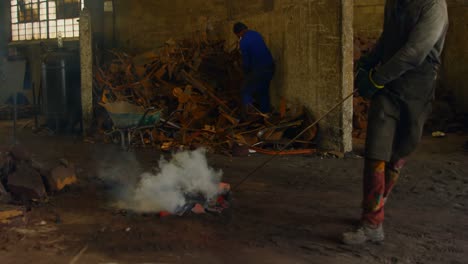 male worker pulling hot molted metal in workshop 4k