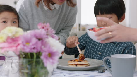 행복한 아시아 가족이 아침 식사로 팬케이크를 먹고 아이들이 주말 아침에 부 ⁇ 에서 부모와 함께 건강한 집에서 만든 식사를 즐기고 있습니다. 4k 영상