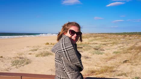 Woman-walking-at-the-beach-path-and-looking-to-the-camera,-in-slow-motion