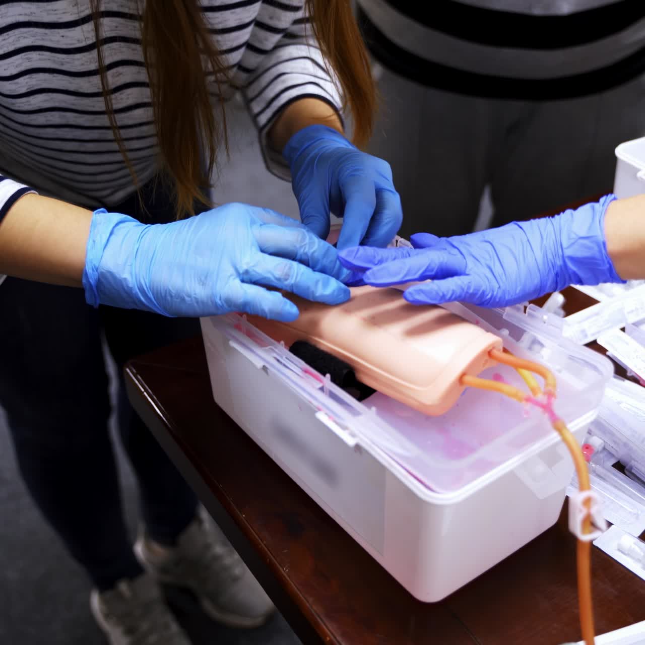 Doctor in gloves making injection with a syringe for puncture. Simulation medical training model. Medical procedure concept, simulation medicine training