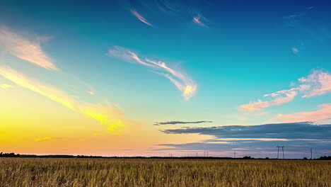 Zeitraffer-Von-Zirruswolken,-Die-Hoch-über-Dem-Himmel-Inmitten-Eines-Gelb-Beleuchteten-Sonnenuntergangshimmels-über-Maisfeldern-In-Lettland-Fegen