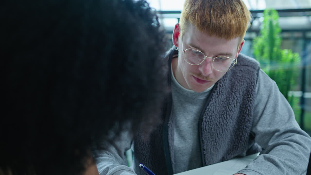 Gen Z Man Presenting Business Project and Giving Papers to Team