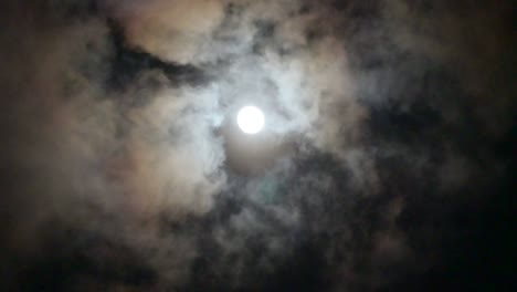 clouds are moving through the full moon, the atmosphere looks mysterious and scary. 4k video.