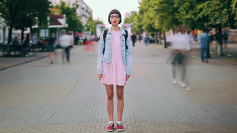 woman in pink dress and denim jacket on city street