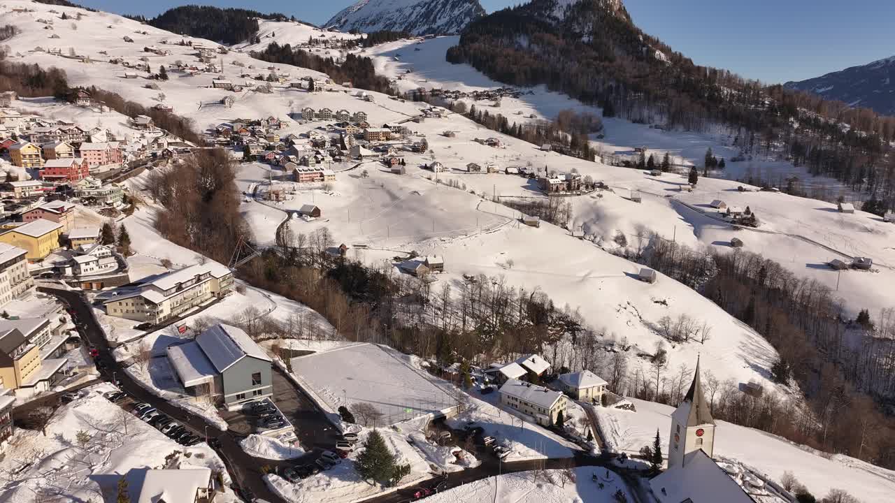 Stunning aerial view of Amden, Arvenbüel and Walensee in Switzerland, picturesque villages in breathtaking alpine landscape, drone moves forward to snow-covered mountains and serene beauty of winter.