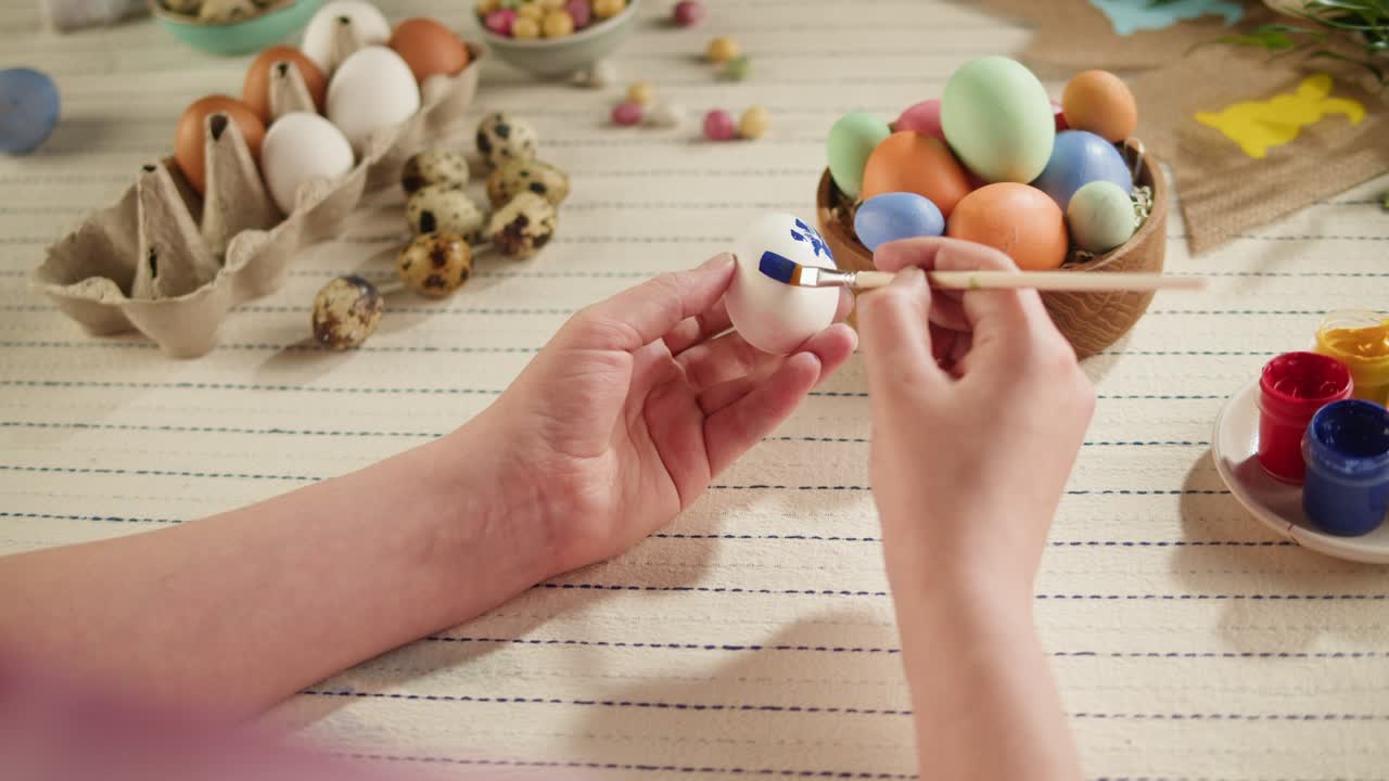 Happy Easter holiday. Coloring eggs top view. Woman preparing for Easter, painting and decorating eggs. Christian celebration, family traditions.