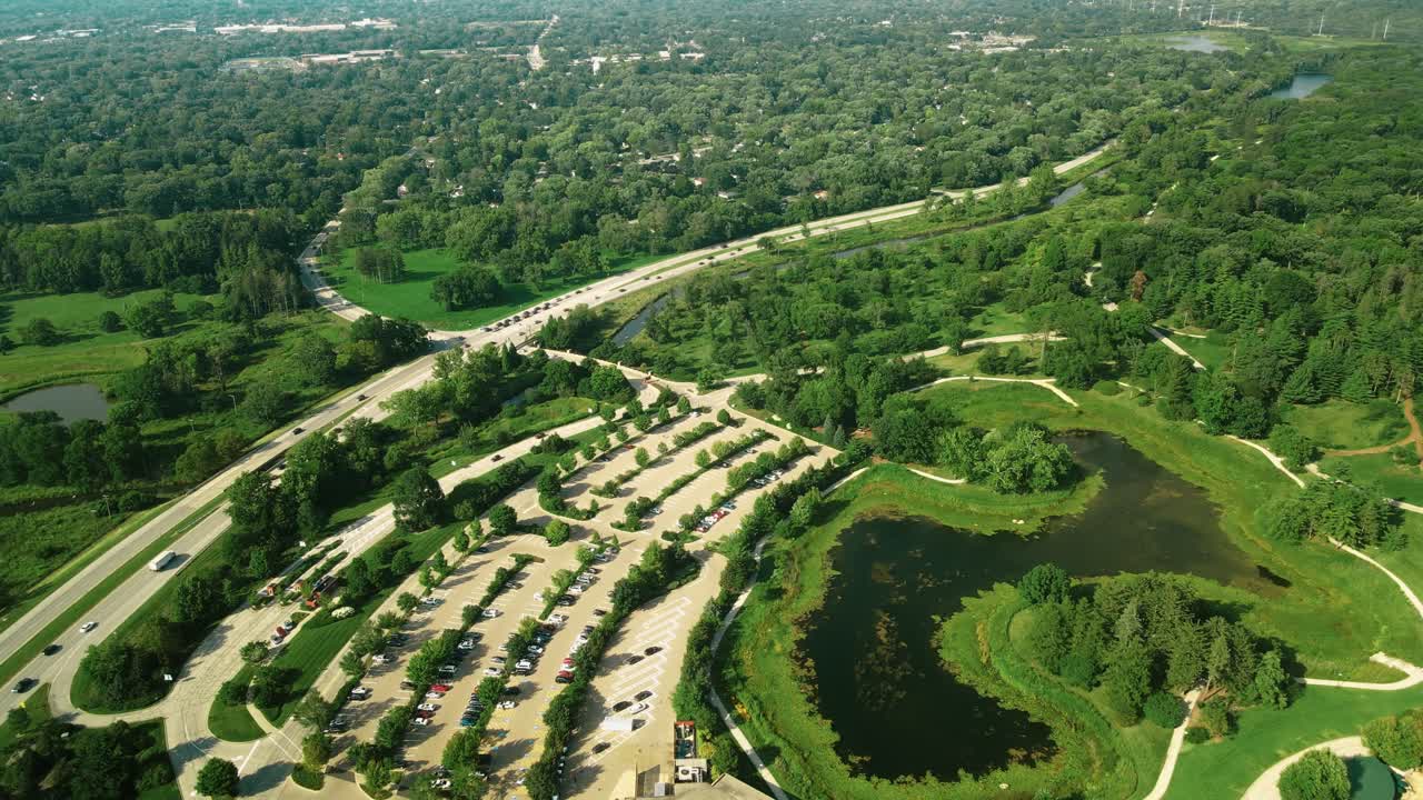 una toma aérea del parque morton arboretum junto con el jardín verdoso y una carretera asfaltada que también se ve fuera del parque