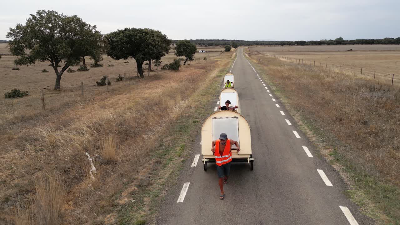 Nomad family pulling small homes on wheels in countryside in Spain