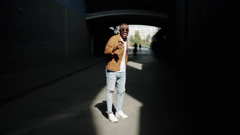 stylish man dancing in an urban tunnel