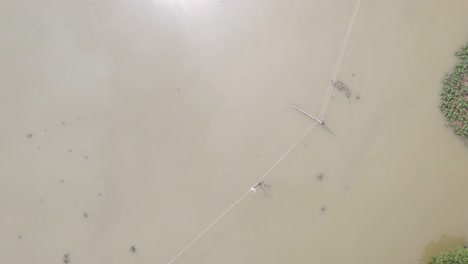 above view of electric pole in a flooded area in bangladesh, south asia. aerial topdown shot