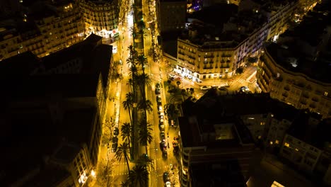 Hyperlapse-of-a-busy-main-street-at-night-in-the-center-of-valencia-located-in-spain-,-this-golden-hyperlapse-shows-main-street-at-night-with-a-line-of-trees-down-the-middle-of-the-road