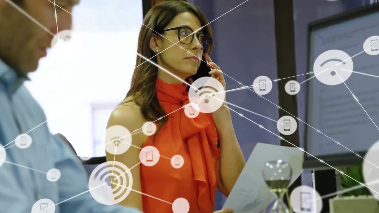 animación de iconos conectados sobre una mujer biracial hablando por teléfono móvil en la oficina.