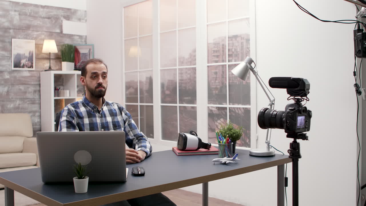 Man vlogging with camera and laptop