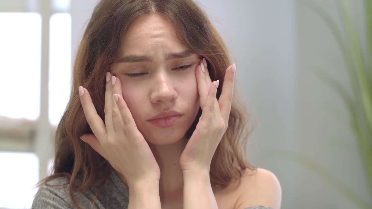 욕실 거울에서 얼굴 피부를 만지는 불만족한 여성. 문제 피부 개념