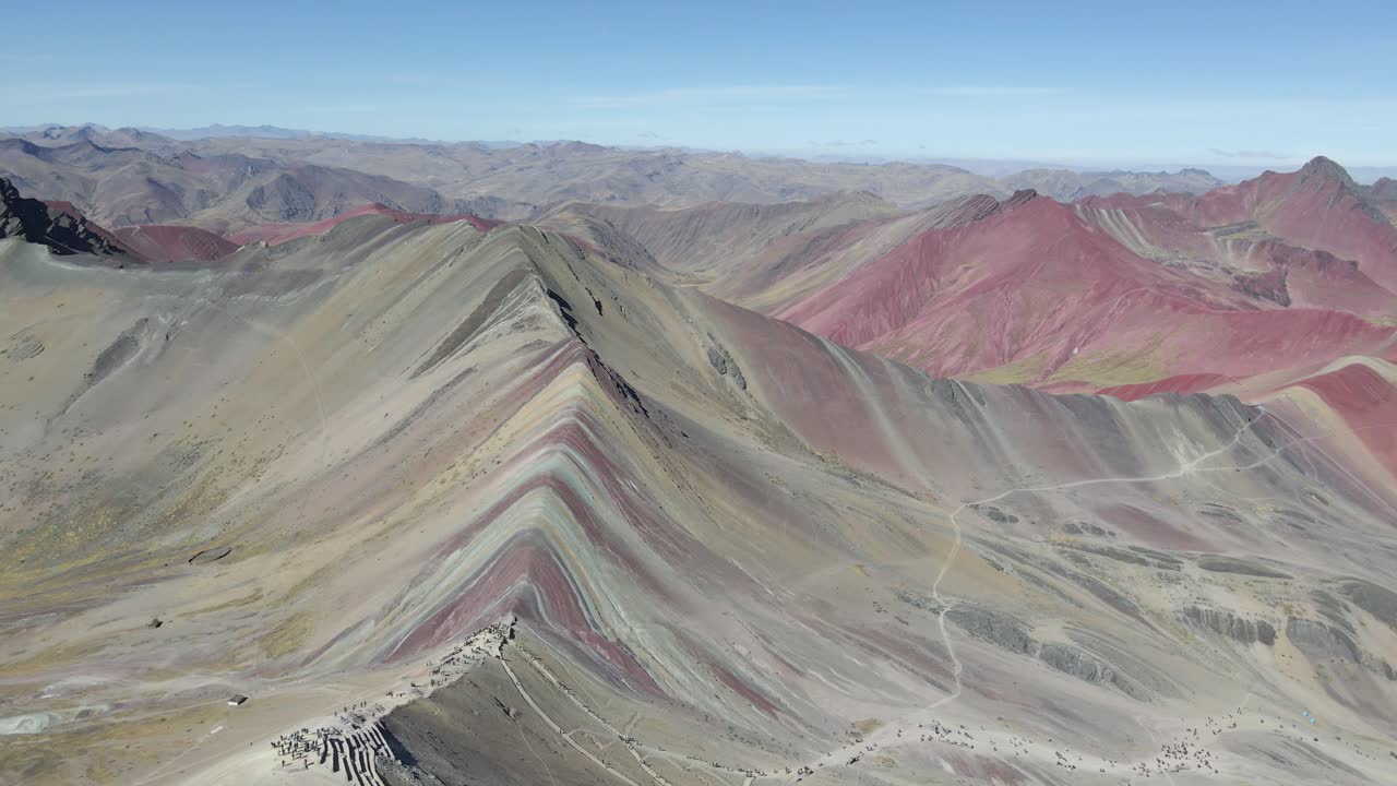 Voo reverso captura a Montanha Arco-Íris do Peru em espetáculo de drone com o vale vermelho ao fundo
