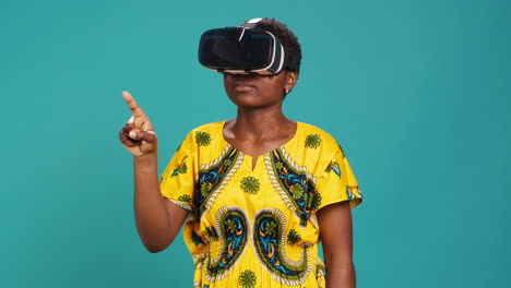 Gorgeous-girl-in-ethnic-clothes-using-vr-glasses-against-blue-background