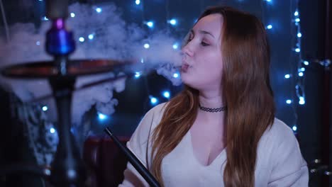 mujer disfrutando de un narguile en un club nocturno