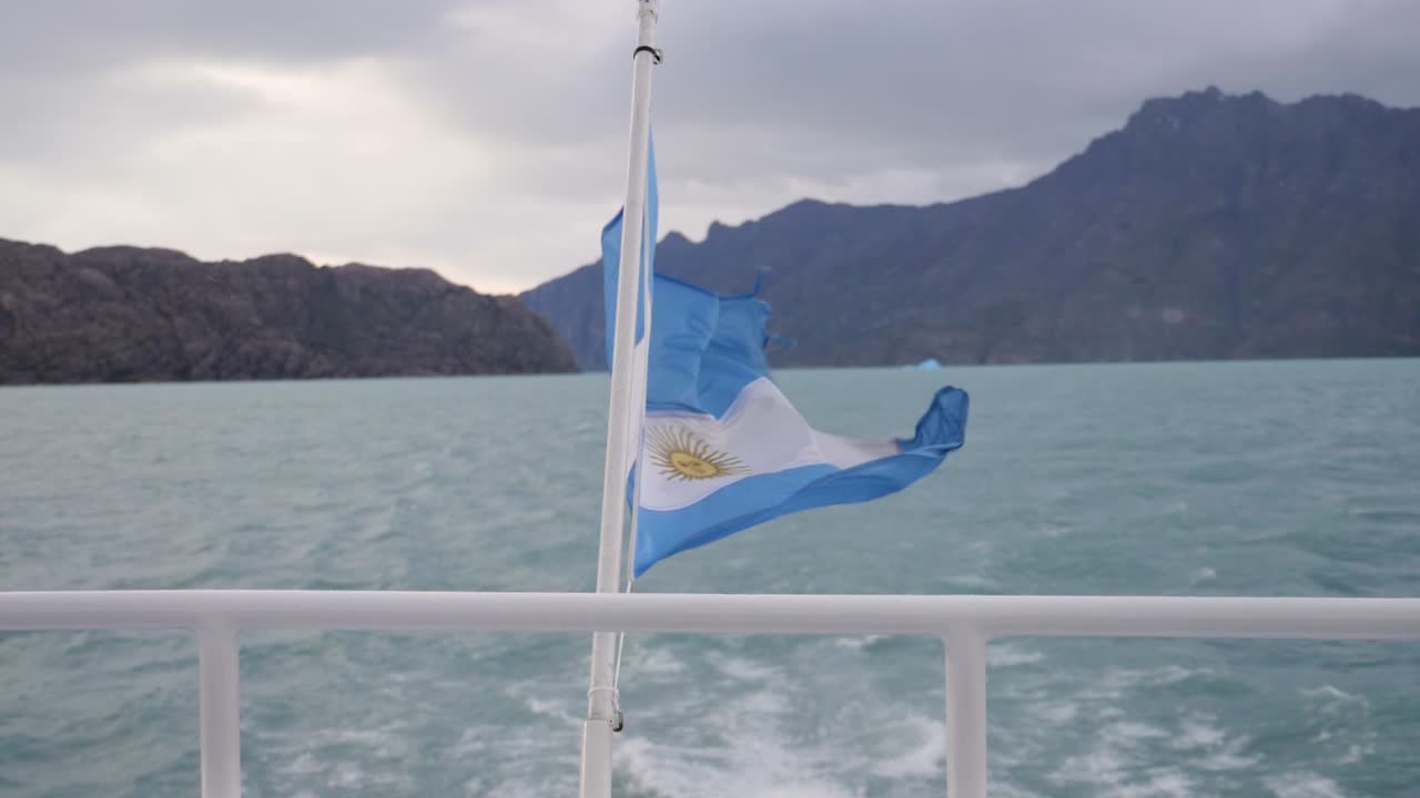 toma lenta de la bandera argentina en el lago argentino moviéndose en un bote