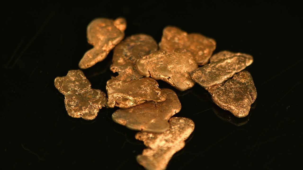 회전하는 금 조각 (근접 영상; 선택적 초점)