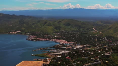 Port-Moresby-Harbour-Marina-Papua-New-Guinea-beautiful-sunny-blue-sky-morning-Ela-Beach-parallax-aerial-drone-car-traffic-PNG-Crown-Hotel-Plaza-Hilton-Walter-Bay-Coral-Sea-capital-city-circle-left