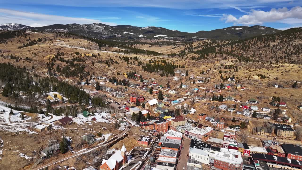Historic downtown buildings Central City Black Hawk Colorado aerial drone view city townhall winter sunny daytime blue sky Gold mining town tailings neighborhood streets casinos static shot