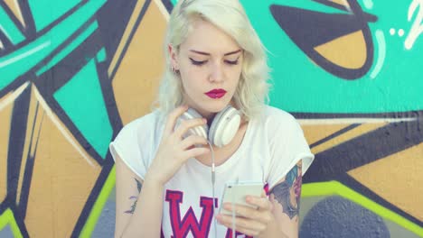 trendy young woman with tattoos listening to music