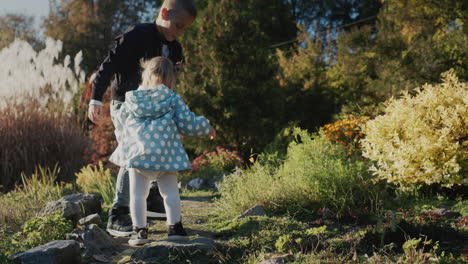 Bruder-Spielt-Mit-Kleiner-Schwester-Im-Herbstpark