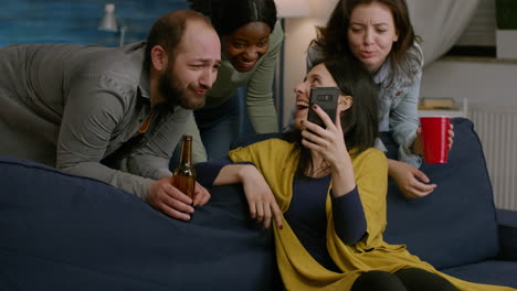group of mixed race people spending time together while looking at comedy video