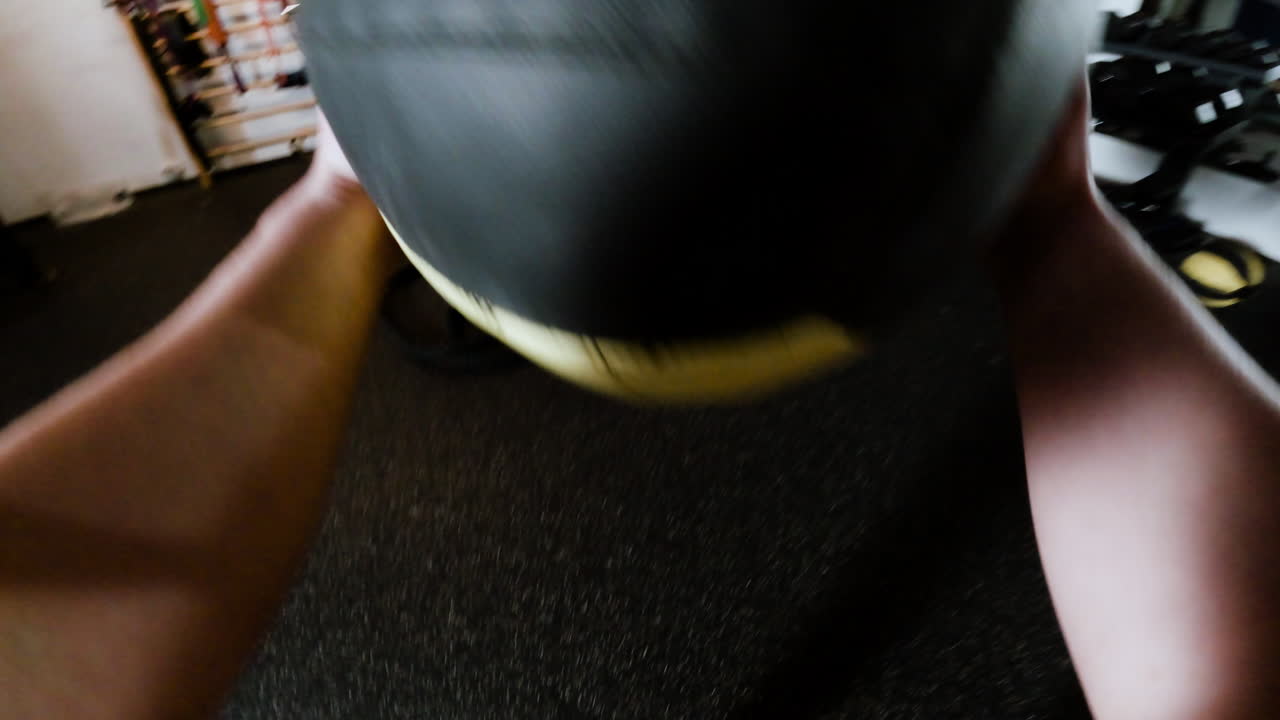 Person holding a medicine ball in a gym