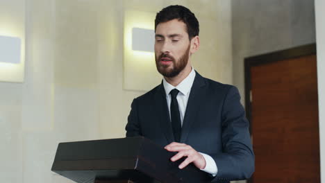 caucasian businessman speaker on a podium at a conference and interacting with people in the hall during his speech