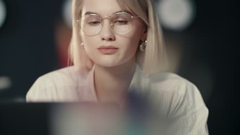 pensive business woman looking laptop computer in dark office.