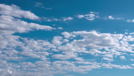 time lapse: white stratocumulus and stratus cloud formations in bright blue sky