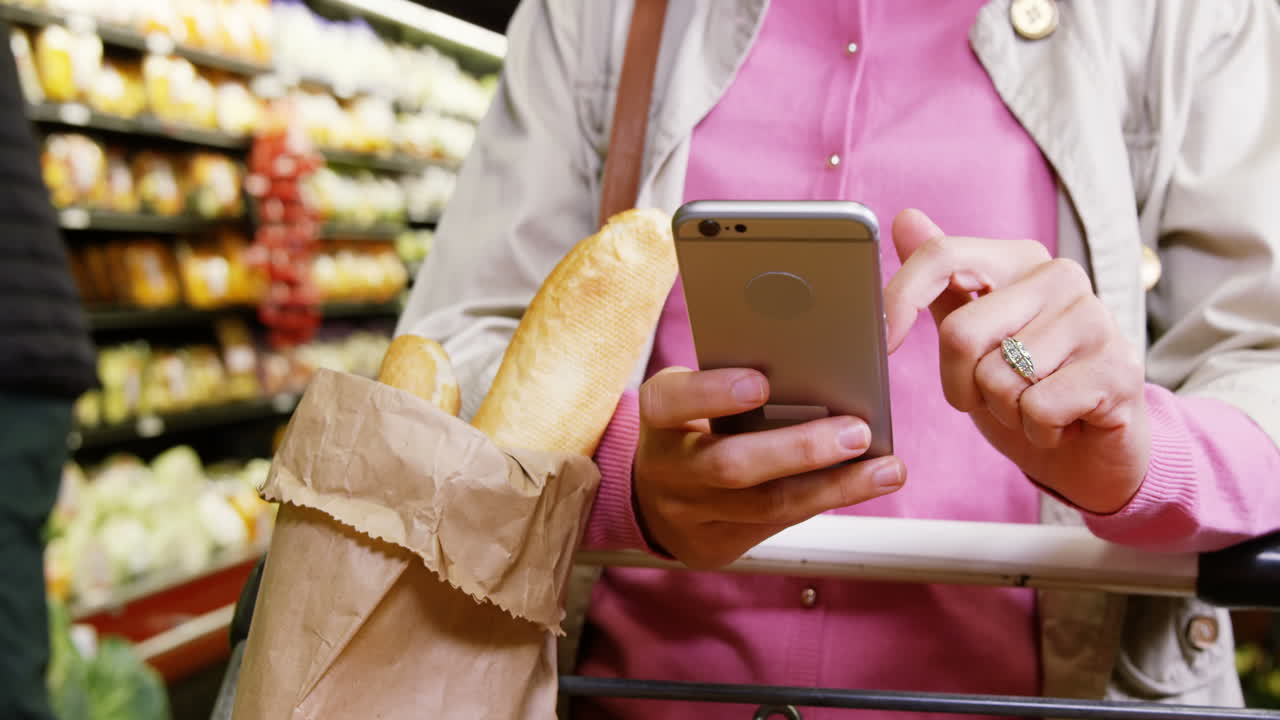 mujer usando el teléfono móvil mientras hace compras