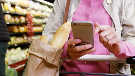 Woman-using-mobile-phone-while-shopping