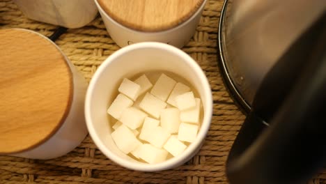 sugar cubes in a container on a kitchen table