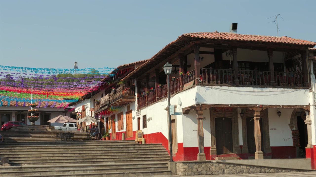 Centro storico di Tapalpa Pueblo Mágico con tradizionali edifici imbiancati a calce, balconi in legno e colorate decorazioni stradali a Jalisco, Messico. Inquadratura di ambientazione.