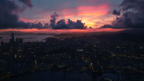 Zeitraffer-Des-Sonnenuntergangs-über-Der-Stadt-Hongkong,-Rückwärts-Fliegende-Weitwinkelaufnahme-Aus-Der-Luft