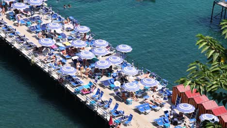 crowded pier with umbrellas and sunbathers