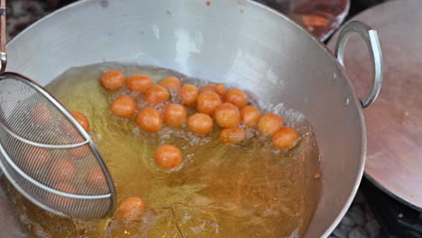 a traditional arab sweet called al logimat is being prepared in a street of dubai